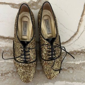 Jimmy Choo gold glitter smoking shoe with black piping and laces. Size 41.